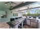 Covered outdoor kitchen with bar seating, stainless steel appliances, and a view of the pool at 10007 Hazelnut Ct, Tampa, FL 33647