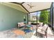 Relaxing screened patio with comfortable seating and a colorful rug overlooking the backyard at 10007 Hazelnut Ct, Tampa, FL 33647