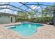 Backyard pool with an attached jacuzzi tub surrounded by brick pavers and a screened in patio at 10007 Hazelnut Ct, Tampa, FL 33647
