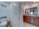 Well lit bathroom with double vanity, tile floors, and view of toilet at 10222 Cool Waterlily Ave, Riverview, FL 33578