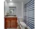 Bathroom with a dark wood vanity with granite countertop and patterned shower curtain at 10222 Cool Waterlily Ave, Riverview, FL 33578