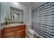 Neutral-toned bathroom with granite vanity, mirror, and patterned shower curtain at 10222 Cool Waterlily Ave, Riverview, FL 33578
