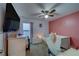 Cozy bedroom features a ceiling fan, window, desk, and is decorated with a pink accent wall at 10222 Cool Waterlily Ave, Riverview, FL 33578