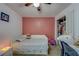 A well lit bedroom with a closet, ceiling fan, and pink accent wall at 10222 Cool Waterlily Ave, Riverview, FL 33578