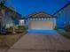 Charming single-story home featuring an attached two-car garage and festive blue lights at 10222 Cool Waterlily Ave, Riverview, FL 33578