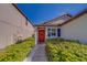 Inviting home entrance with a red front door and lush green landscaping at 10222 Cool Waterlily Ave, Riverview, FL 33578