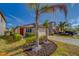 Charming one-story home featuring a red door, palm trees, and well-manicured landscaping at 10222 Cool Waterlily Ave, Riverview, FL 33578