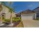 Charming home featuring a two-car garage, well-maintained landscaping, and a red front door at 10222 Cool Waterlily Ave, Riverview, FL 33578