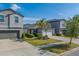 Street-level view of a house with solar panels, tree, and well-manicured lawn at 10222 Cool Waterlily Ave, Riverview, FL 33578