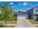 Charming home featuring a two-car garage, well-maintained landscaping, and beautiful tree at 10222 Cool Waterlily Ave, Riverview, FL 33578
