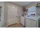 Functional laundry room with washer, dryer, shelving, and natural light at 10222 Cool Waterlily Ave, Riverview, FL 33578