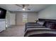 Comfortable carpeted main bedroom with ceiling fan, window, and ensuite bathroom entrance at 10222 Cool Waterlily Ave, Riverview, FL 33578