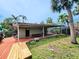 Backyard view with a spacious wooden deck, green grass, and palm trees at 103 1St St, Belleair Beach, FL 33786