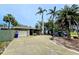 Charming single-story home with a two-car garage, lush landscaping, and a long driveway at 103 1St St, Belleair Beach, FL 33786