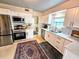 Well-lit kitchen with stainless steel appliances, white cabinetry, and ample counter space at 103 1St St, Belleair Beach, FL 33786