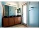 Bathroom featuring double sinks, vanity, mirrors and a door to the outside at 10400 Golden Ave, Weeki Wachee, FL 34613