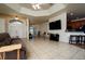 Bright living room featuring tiled floors, ceiling fan, and adjacent kitchen with breakfast bar at 10400 Golden Ave, Weeki Wachee, FL 34613