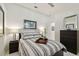 Comfortable bedroom with a striped comforter, matching nightstands, and black dresser for ample storage at 10608 Gretna Green Dr, Tampa, FL 33626