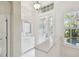 Bright foyer features white cabinets, a glass door, decorative art, and plantation shutters at 10608 Gretna Green Dr, Tampa, FL 33626