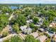 Aerial view of a quiet neighborhood with lush trees, a community lake, and a grassy field at 1115 Crescent Lake N Dr, St Petersburg, FL 33701