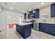 Modern kitchen with stainless steel appliances, white countertops, and contrasting blue cabinets at 1115 Crescent Lake N Dr, St Petersburg, FL 33701