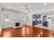 Sun-filled living room with hardwood floors, a white brick fireplace, and an adjacent blue kitchen at 1115 Crescent Lake N Dr, St Petersburg, FL 33701