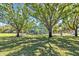 Community playground featuring lush green grass and mature trees providing plenty of shade at 1115 Crescent Lake N Dr, St Petersburg, FL 33701