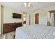 Bright bedroom features a ceiling fan, wood floors, TV, walk-in closet, and an en suite bathroom at 115 112Th Ne Ave # 1027, St Petersburg, FL 33716