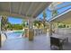 Charming patio area with seating, overlooking a sparkling pool and lush tropical landscaping at 115 112Th Ne Ave # 1027, St Petersburg, FL 33716