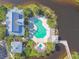 Aerial view of a uniquely shaped pool, clubhouse, and cabana, surrounded by tropical landscaping at 115 112Th Ne Ave # 1027, St Petersburg, FL 33716