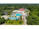 Aerial view of a community recreation center featuring a pool, parking lot, playground and tennis courts at 11510 Moffat Pl, Temple Terrace, FL 33617