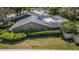 An aerial view showcasing the home's roof, landscaping, and a screened-in pool at 11510 Moffat Pl, Temple Terrace, FL 33617