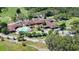 An aerial view of a clubhouse situated next to a lush green golf course and a sparkling pool at 11510 Moffat Pl, Temple Terrace, FL 33617