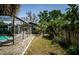A view of the backyard featuring a screened in pool, privacy fence and shaded lawn at 11510 Moffat Pl, Temple Terrace, FL 33617
