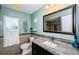 Stylish bathroom with a granite countertop, decorative mirror, and tile accents at 11510 Moffat Pl, Temple Terrace, FL 33617