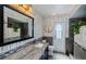 Stylish bathroom with granite countertop, decorative mirror, unique wallpaper, and modern fixtures at 11510 Moffat Pl, Temple Terrace, FL 33617