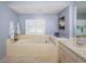 Bright bathroom with a soaking tub, tiled surround, and updated vanity at 11510 Moffat Pl, Temple Terrace, FL 33617