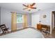 Comfortable bedroom with wood-look floors, a ceiling fan, and a dedicated desk area at 11510 Moffat Pl, Temple Terrace, FL 33617