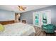 A cozy, blue-walled bedroom featuring vinyl floors, a plush chair, and access to a sunroom at 11510 Moffat Pl, Temple Terrace, FL 33617