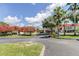 Community center with lush landscaping, including red flowering trees, an American flag and ample parking at 11510 Moffat Pl, Temple Terrace, FL 33617