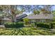 Charming brick home with a well-manicured lawn and mature trees creating a beautiful landscape at 11510 Moffat Pl, Temple Terrace, FL 33617