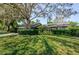 Brick home featuring lush green lawn and mature trees providing shade and curb appeal at 11510 Moffat Pl, Temple Terrace, FL 33617