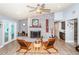 Living room featuring a brick fireplace, ceiling fan, wood-look flooring, and a seating area at 11510 Moffat Pl, Temple Terrace, FL 33617