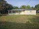 Expansive backyard featuring a well-maintained lawn and a screened patio, ideal for outdoor enjoyment at 1204 23Rd W Ave, Palmetto, FL 34221