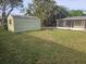 Lush backyard features a storage shed and screened patio area, perfect for storage and enjoying the outdoors at 1204 23Rd W Ave, Palmetto, FL 34221