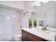 Cozy bathroom features a tiled shower over tub and a dark wood vanity with white countertop at 12170 Lake Allen Dr, Largo, FL 33773
