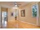 Bedroom with hardwood floors, two windows, ceiling fan, art, and adjacent bedroom view at 12170 Lake Allen Dr, Largo, FL 33773