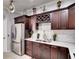Bright kitchen with stainless steel refrigerator, granite countertops, and dark wood cabinets with decor at 12170 Lake Allen Dr, Largo, FL 33773