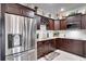 Modern kitchen featuring stainless steel appliances, granite countertops, and dark wood cabinetry at 12170 Lake Allen Dr, Largo, FL 33773
