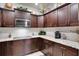 Well-designed kitchen featuring granite countertops, tiled backsplash, and dark wood cabinets with decor at 12170 Lake Allen Dr, Largo, FL 33773